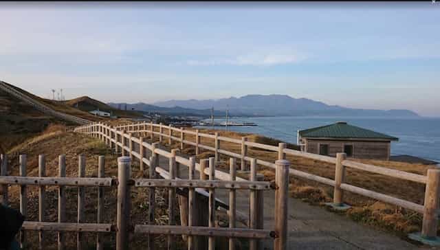 Japan motorcycle rentals ninjatours hokkaido kushiro to ferry tomokamai coastal view with nmountains in the distance